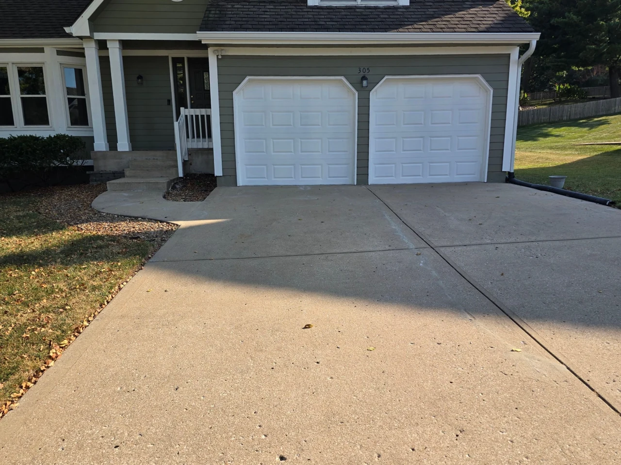 Completed concrete lifting project with a level driveway at the garage and front steps